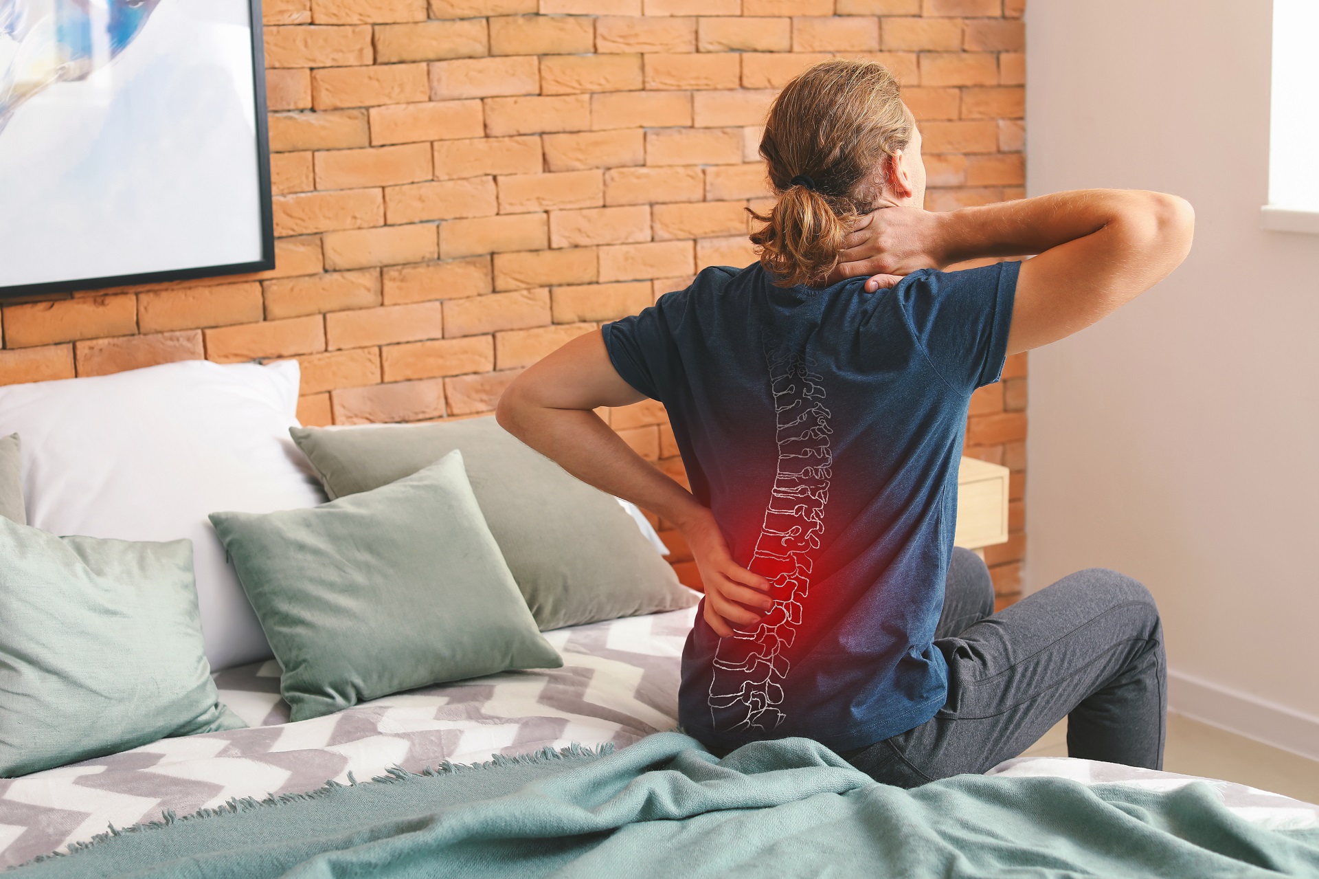 Young man suffering from back pain at home | Hudson Premier PT & Sports in Union City, Jersey City, NJ