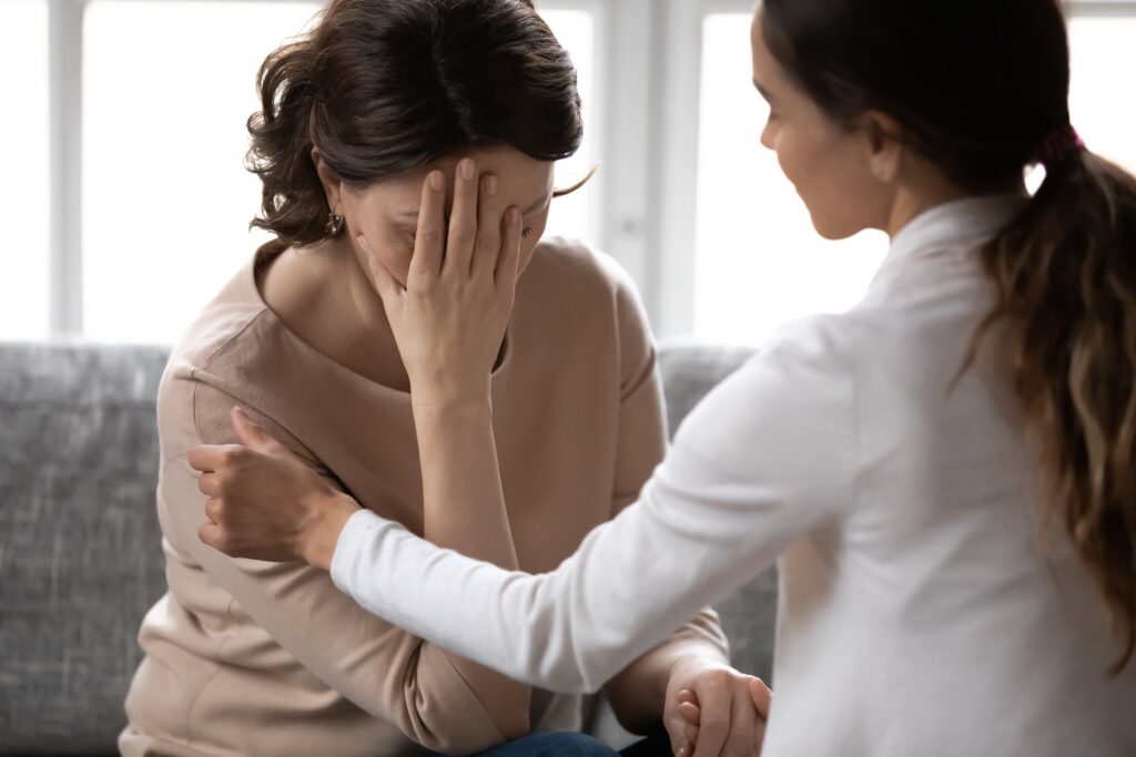 Compassionate kind young woman supporting depressed unhappy middle aged 60s retired mother, giving psychological help, haring advices or comforting at home, trustful family relations concept. | Hudson Premier PT & Sports | Jersey City | Union City | NJ